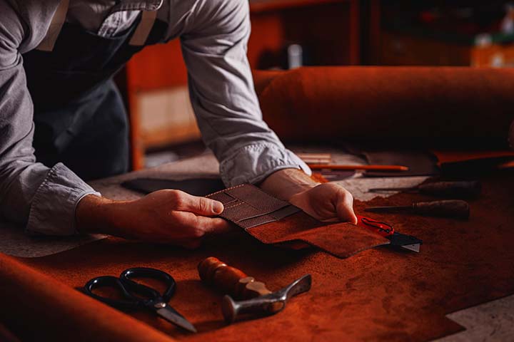 Handicraft production, Craft man tailor checks handmade brown leather product.