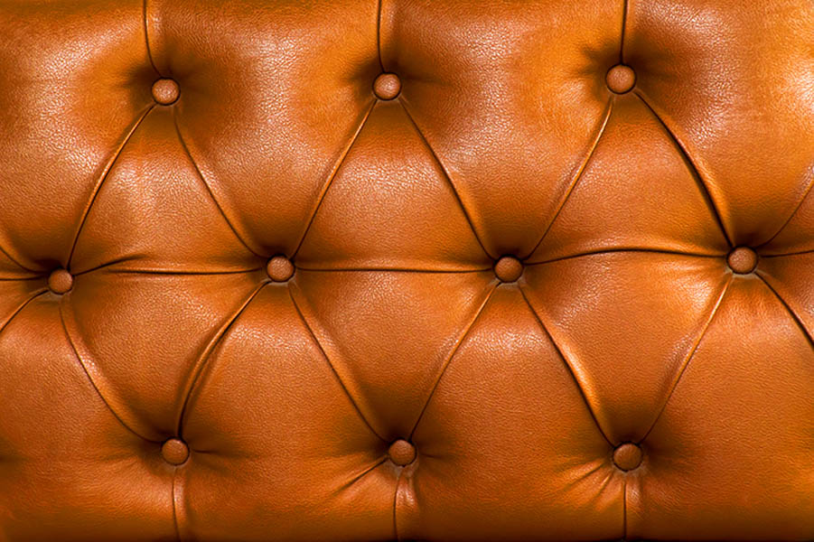 How to Create a Cohesive Look with Upholstered Accessories?; Brown leather upholstery chair with buttons pattern background. Dark brown vintage sofa elegant leather with buttons texture surface